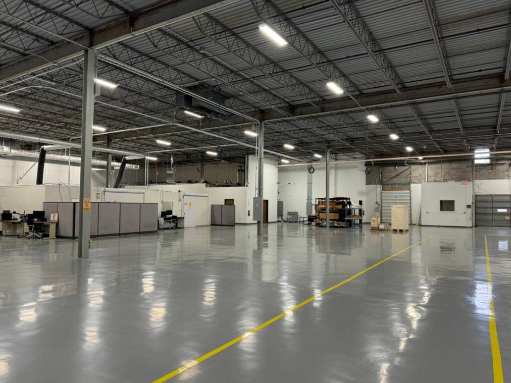 Medical device warehouse in Cleveland, USA: interior with epoxy flooring, yellow-line zoning, office workstations and separate function rooms